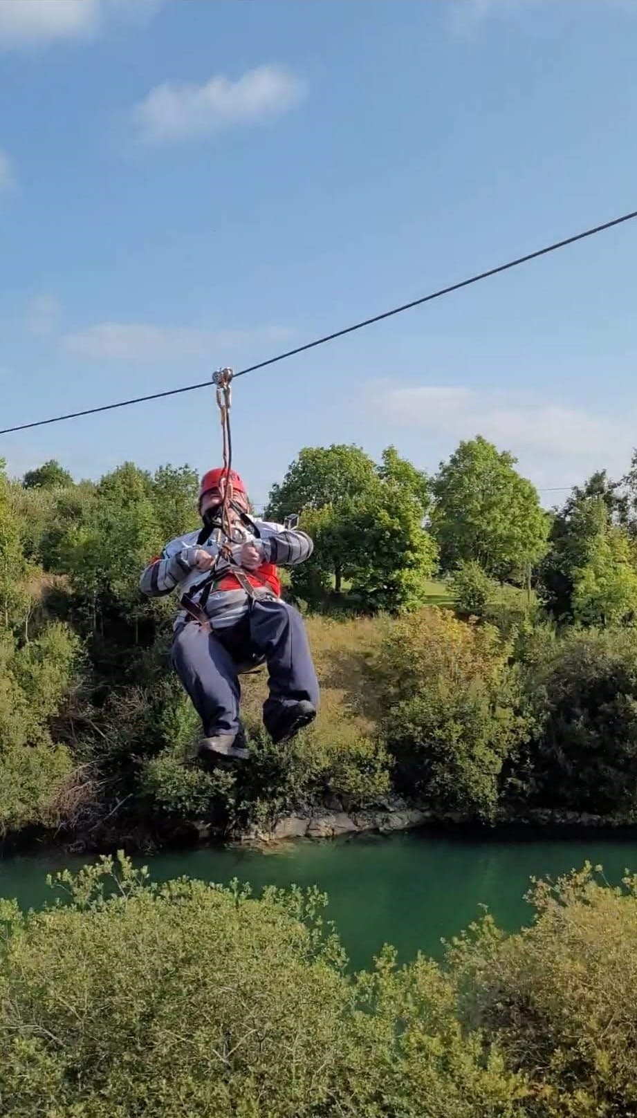 Man Zip Lining With Green Trees in Background 