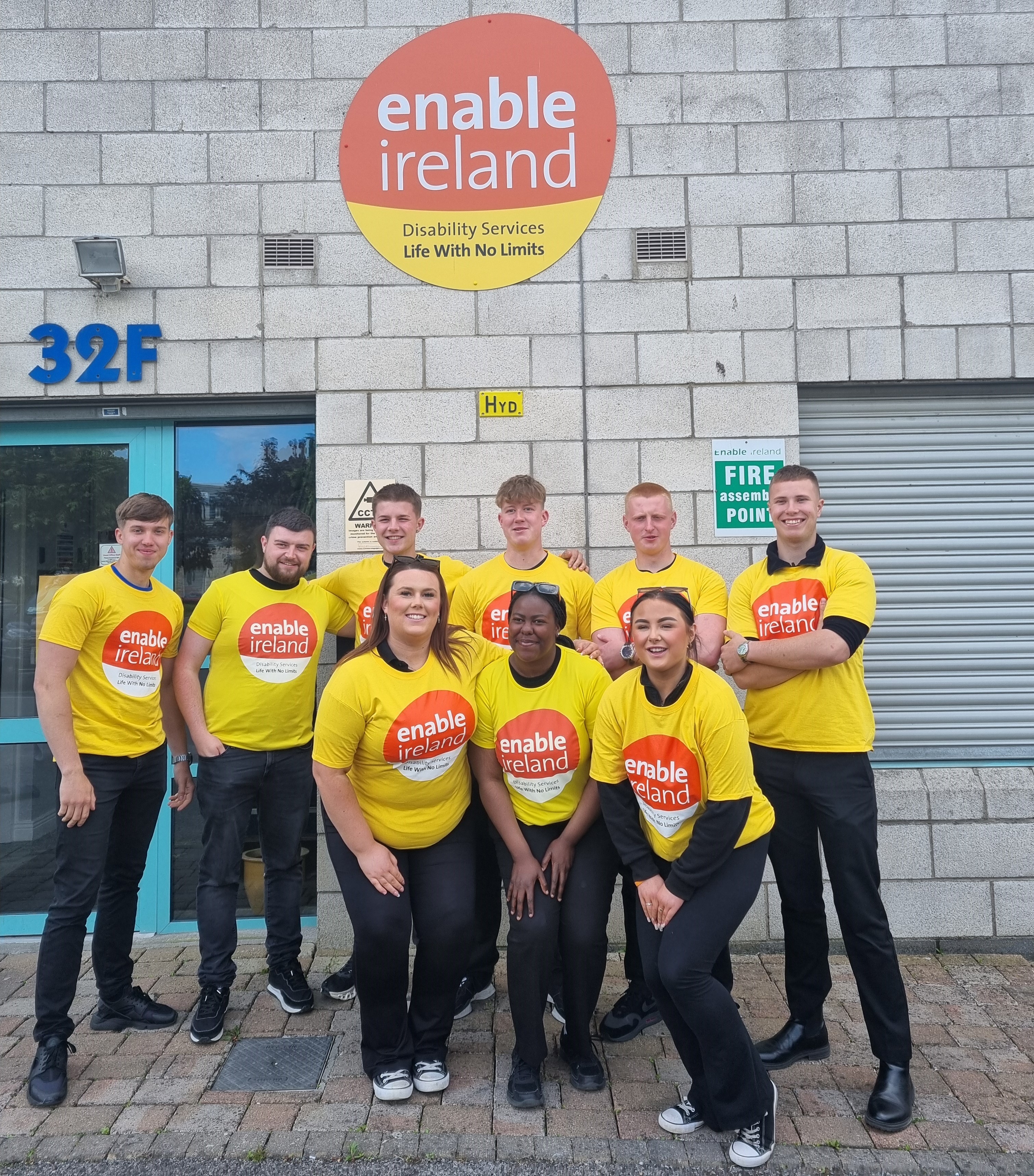 Enable Ireland's Face-to-Face fundraising team standing together outside the Enable Ireland Headquarters in yellow Enable Ireland t-shirts
