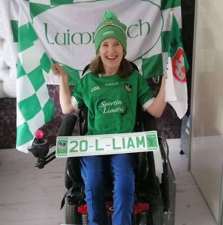 Life With No Limits Champion Sarah O’Sullivan displaying Limerick flags and team colours while seated in a powered wheelchair, celebrating support for Limerick GAA