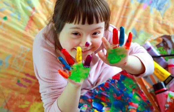 smiling child with paint on hands