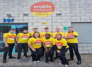Enable Ireland's Face-to-Face fundraising team standing together outside the Enable Ireland Headquarters in yellow Enable Ireland t-shirts