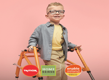 Young boy using a walker and smiling at camera