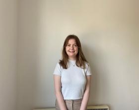 Woman standing against a white wall