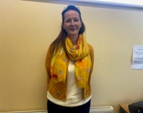 Woman with long brown hair and yellow scarf